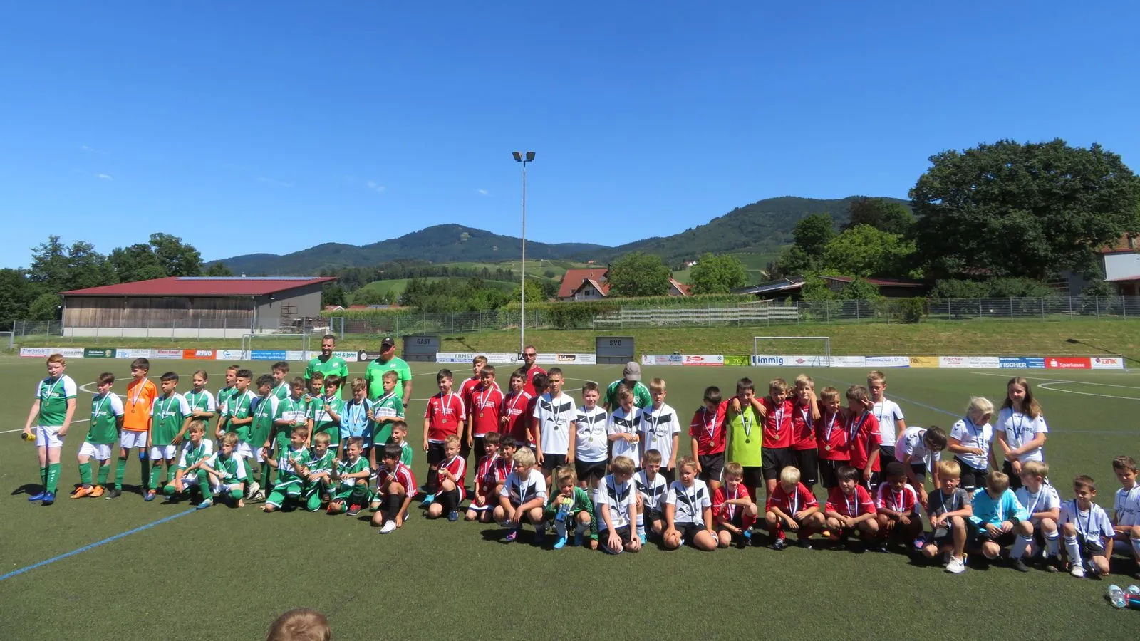 Kinder- und Jugendmannschaften beim Sportfest, mit Medaillen auf dem Sportplatz