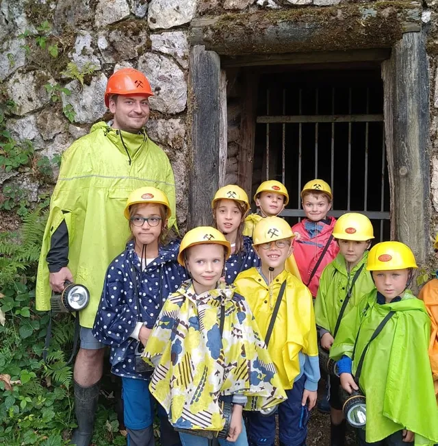 Jugendleiter Martin Straub mit einer Kindergruppe vor dem Stolleneingang des Bergwerks Silbergründle