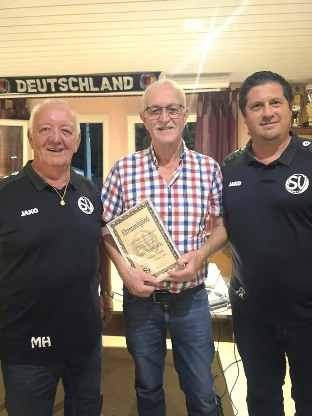Manfred Hörth, Rudi Retsch und Fabian Konzelmann im Clubhaus, Rudi Retsch hält die Urkunde zur Ehrenmitgliedschaft in den Händen