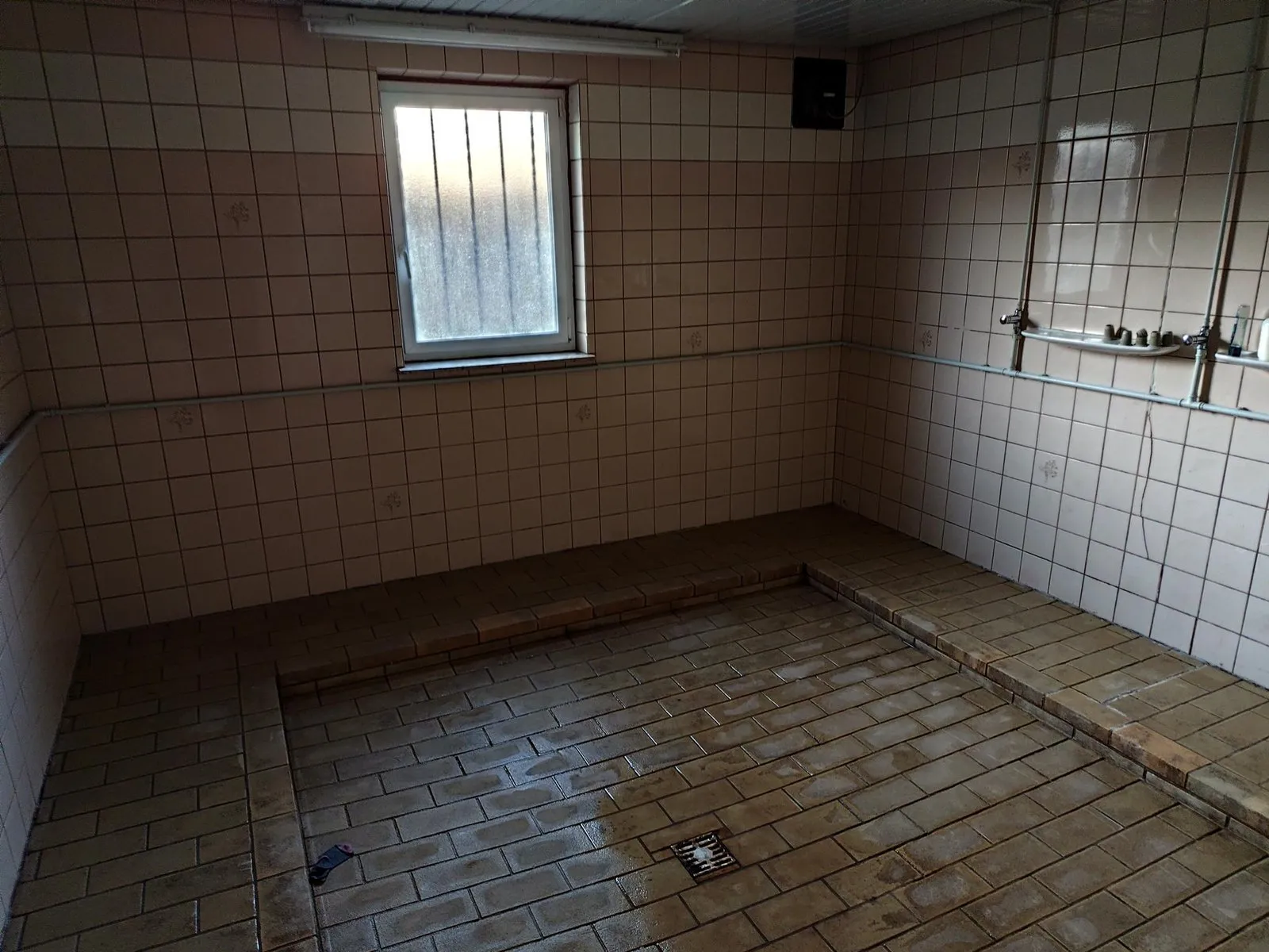 Duschraum im heutigen Clubhaus: alte Fliesen, eine einzige Duschreihe an der Wand